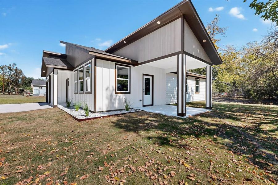 View of side of property with a lawn and a patio area View of side of property with a lawn and a patio area
