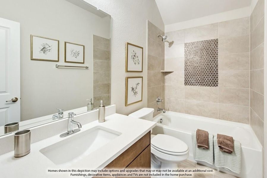 Bathroom with white quartz vanity, wood cabinet, soaking tub, and beige tile surround with hexagon accent tile