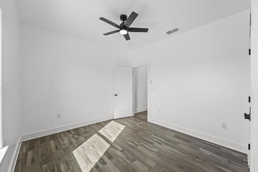 Spare room with dark hardwood / wood-style flooring and ceiling fan