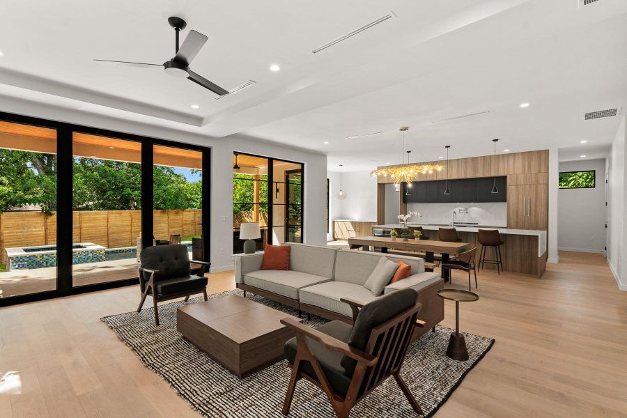 Floor-to-ceiling glass doors open the main living space to the rear yard.