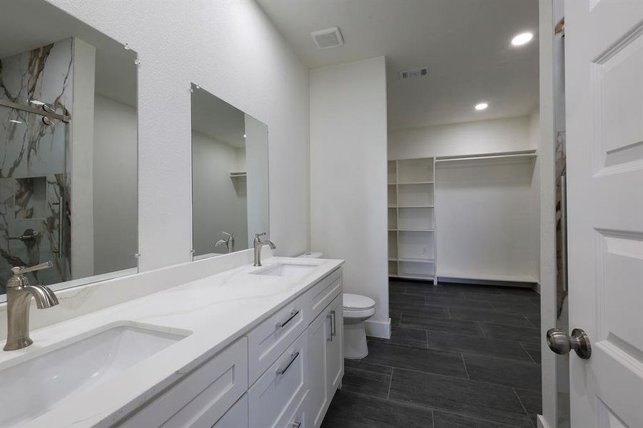 Full bath with double vanity, a walk in closet, a marble finish shower, and recessed lighting Full bath with double vanity, a walk in closet, a marble finish shower, and recessed lighting