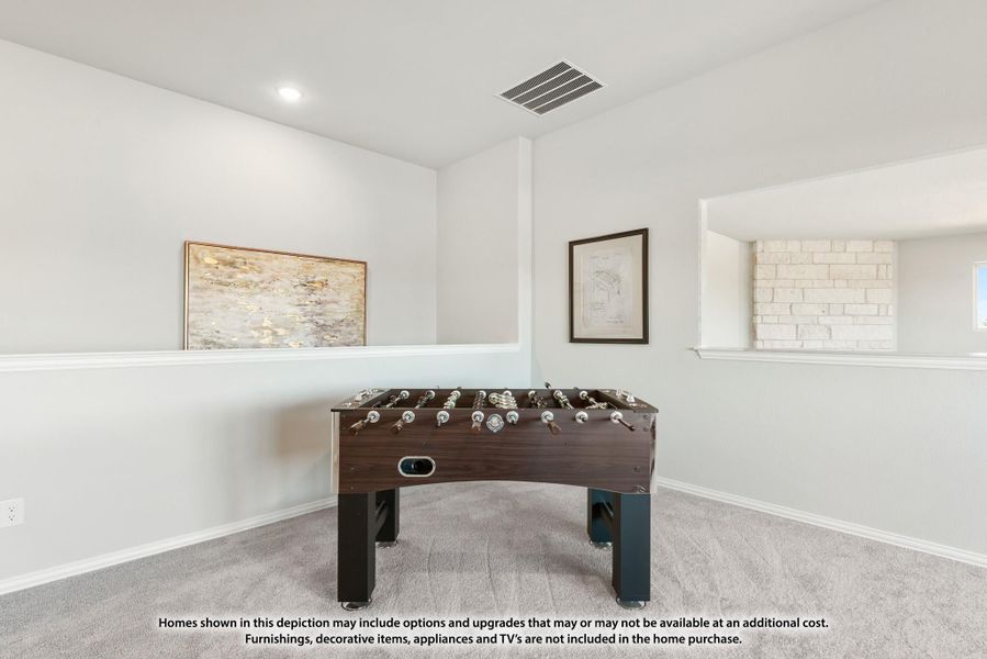 Game room with foosball table, carpet flooring, white walls, and framed artwork