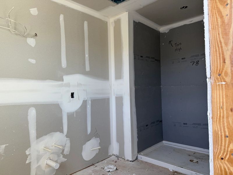 Luxurious primary bathroom features a spa-like glass shower