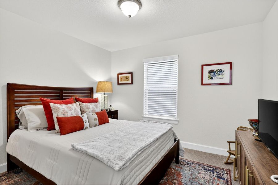 Comfortable first-floor bedroom with plush carpeting, soft neutral palette, and a window for natural light — perfect for guests or extended family. Comfortable first-floor bedroom with plush carpeting, soft neutral palette, and a window for natural light — perfect for guests or extended family.