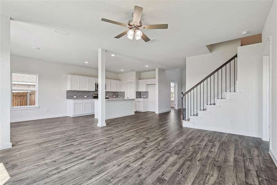 Unfurnished living room with ceiling fan, hardwood / wood-style floors, and a healthy amount of sunlight