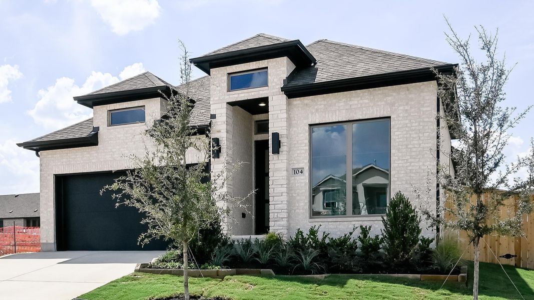 View of front of home with brick siding, a garage, and driveway View of front of home with brick siding, a garage, and driveway