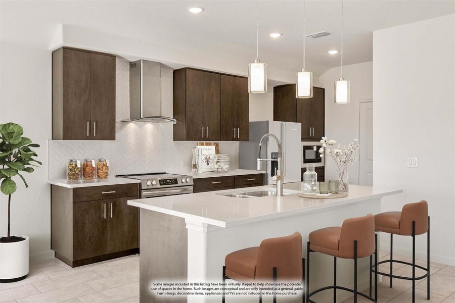 Kitchen with dark wood cabinets, white island with bar seating, pendant lights, and stainless steel appliances