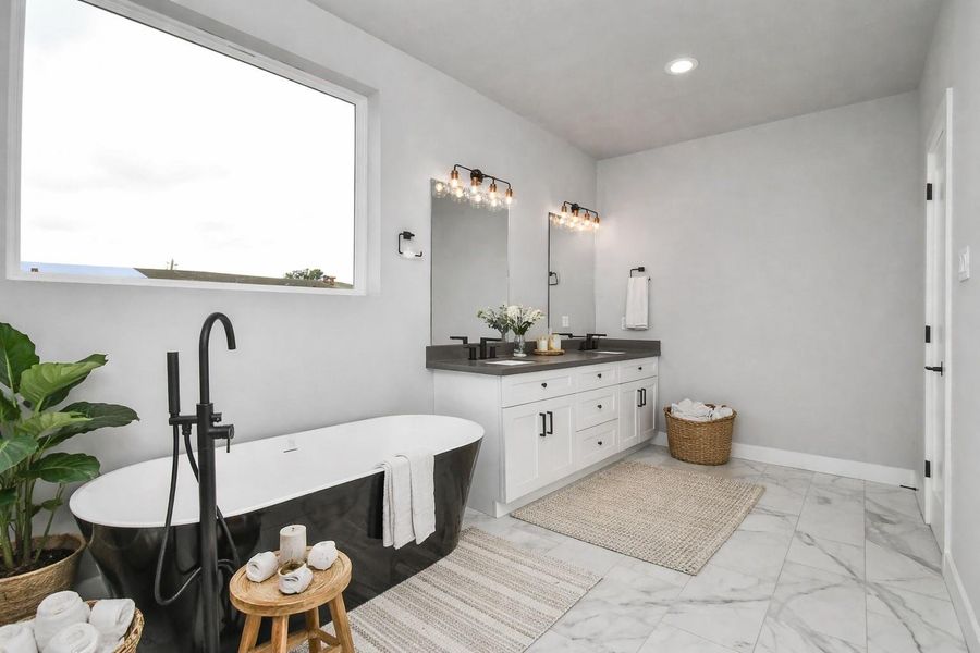 Spa-like bathroom with dual vanities, modern fixtures, and a freestanding soaking tub. Clean, elegant design creates a relaxing retreat.