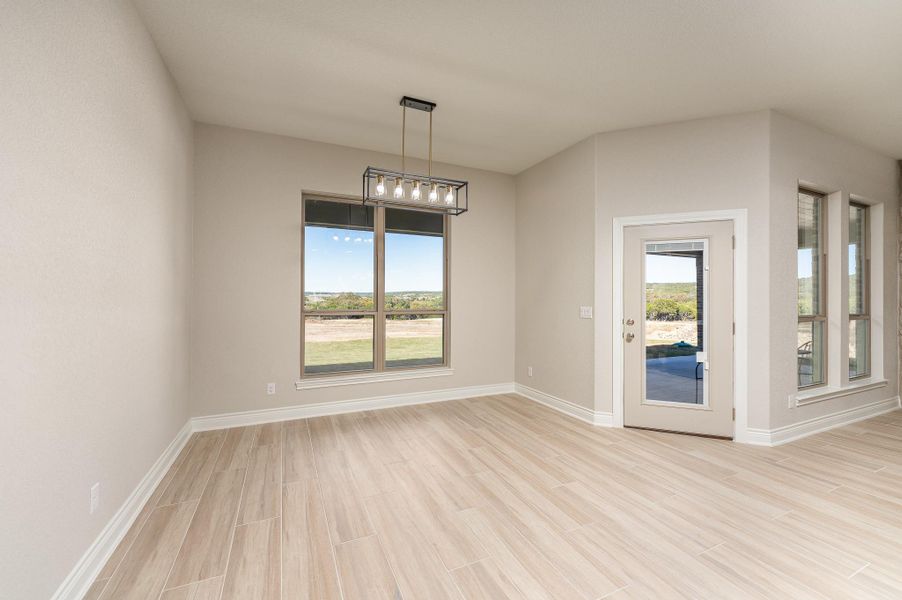 Unfurnished dining area featuring wood tiled floors and healthy amount of natural light Unfurnished dining area featuring wood tiled floors and healthy amount of natural light