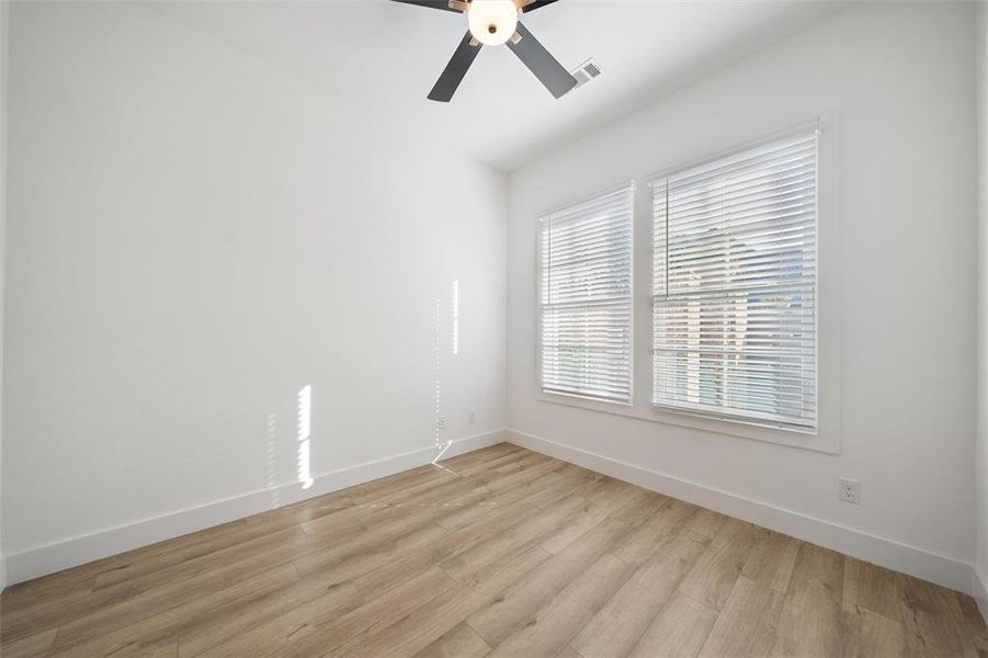 Spare room featuring light wood finished floors and a ceiling fan