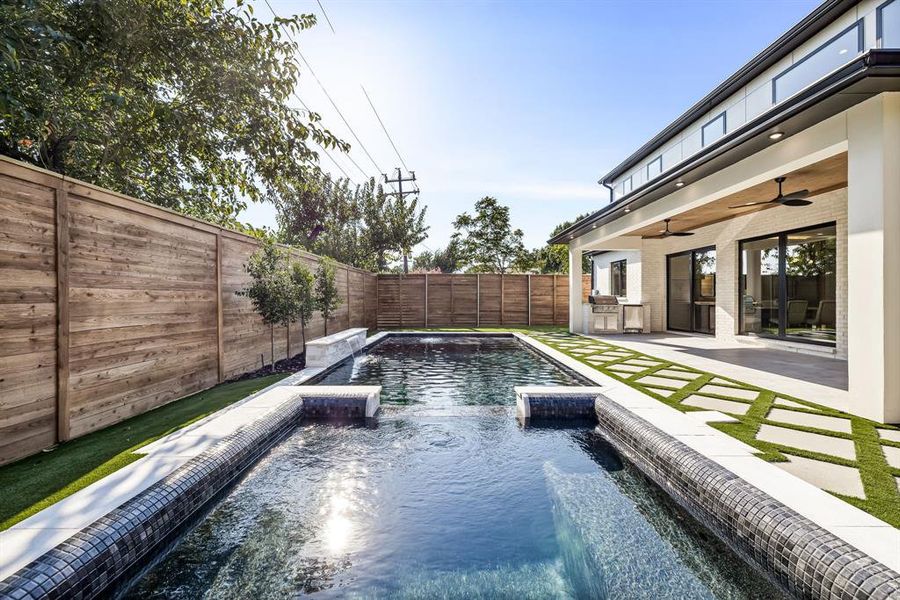 View of pool featuring a fenced backyard, a ceiling fan, a patio, and an outdoor kitchen View of pool featuring a fenced backyard, a ceiling fan, a patio, and an outdoor kitchen