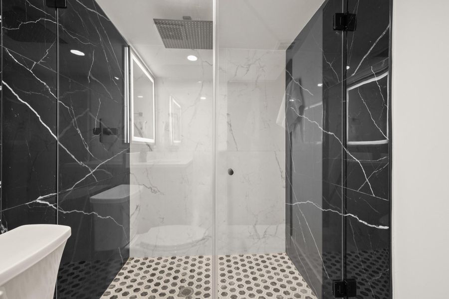 Full bath featuring a marble finish shower