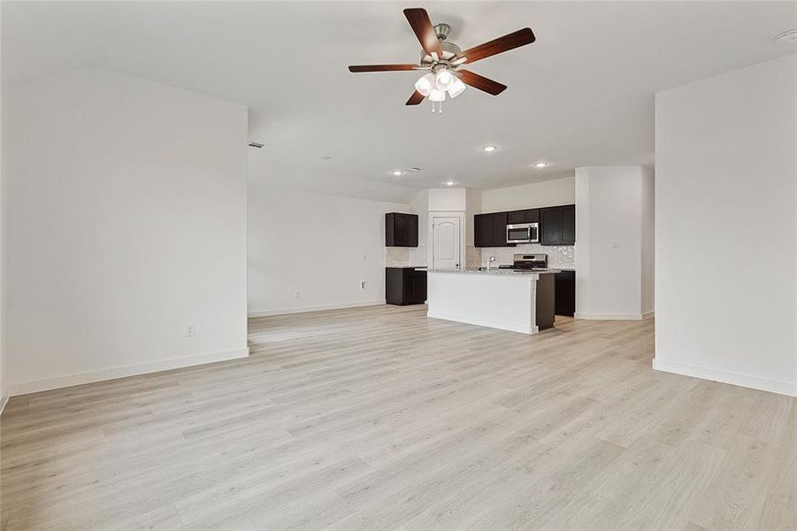 Unfurnished living room with light hardwood / wood-style flooring and ceiling fan