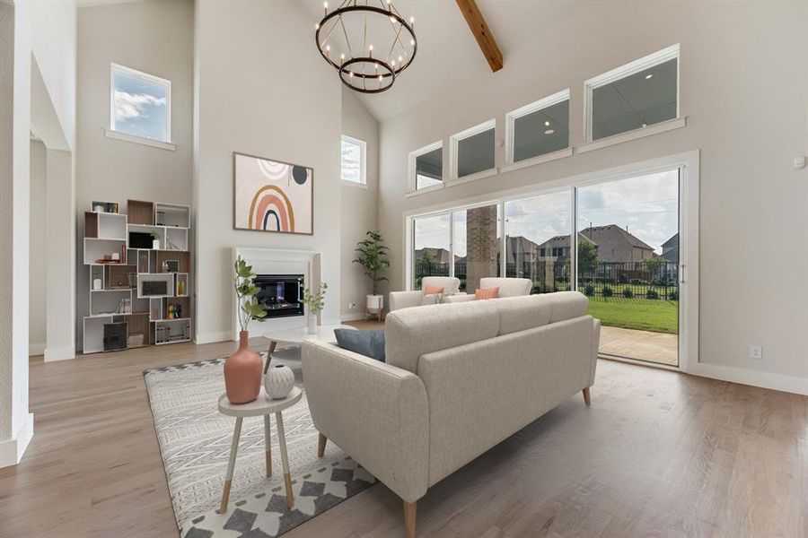 Living area with high vaulted ceiling, a glass covered fireplace, light wood-style flooring, a chandelier, and beamed ceiling Living area with high vaulted ceiling, a glass covered fireplace, light wood-style flooring, a chandelier, and beamed ceiling
