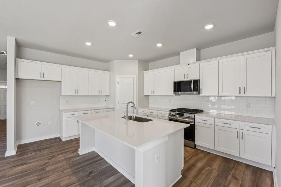 A kitchen with white cabinets.