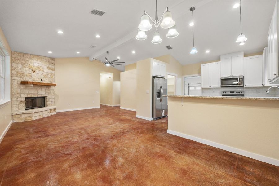 living room with a stone fireplace, a chandelier, ceiling fan, and recessed lighting