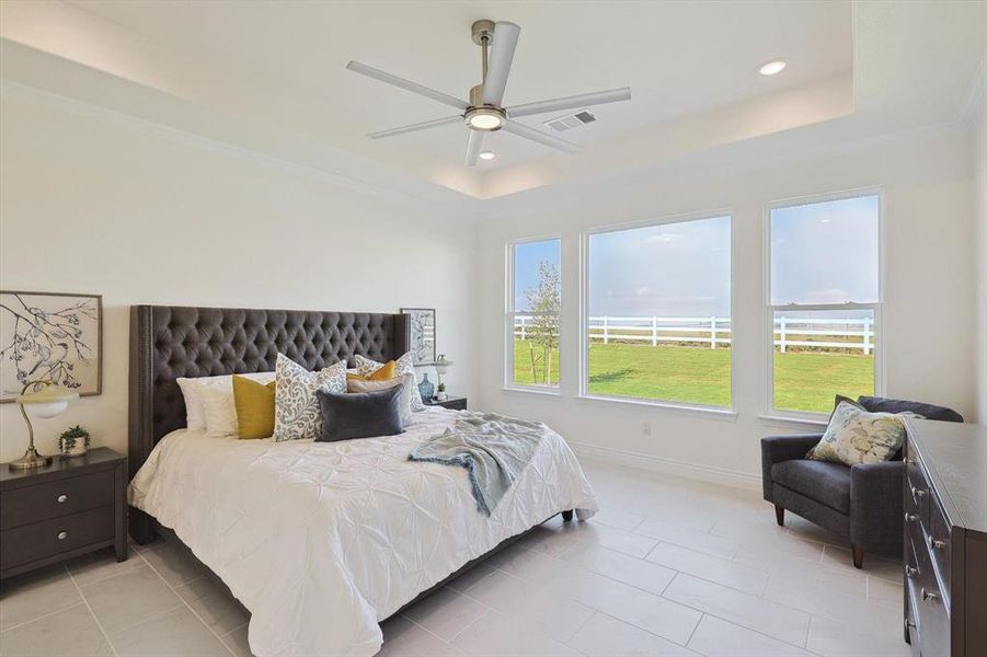 Tiled bedroom with ceiling fan and a raised ceiling