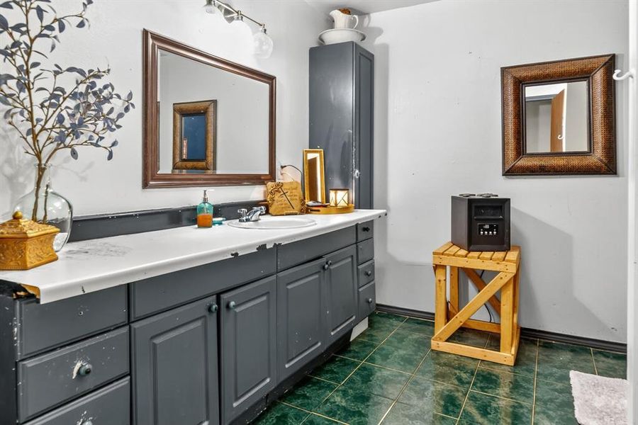 Bathroom featuring vanity and dark tile patterned flooring Bathroom featuring vanity and dark tile patterned flooring