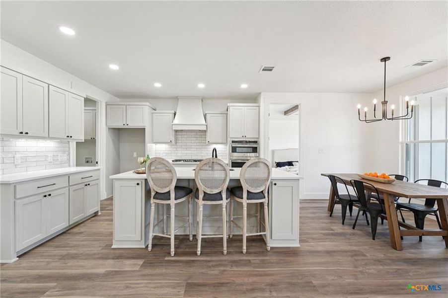Bright, modern kitchen with an inviting island and a well-lit dining area, perfect for entertaining. Bright, modern kitchen with an inviting island and a well-lit dining area, perfect for entertaining.