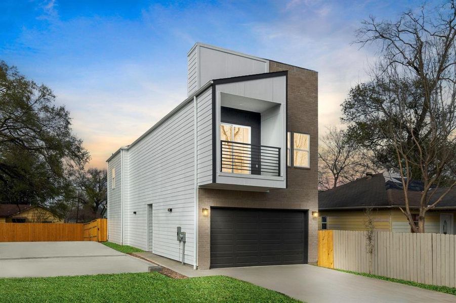 The front of the home from Noble Street, showcasing the inviting entrance, charming balcony, and spacious two-car garage.