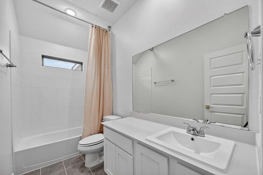 Bathroom featuring a single vanity with an undermount sink, a white countertop, and white cabinet storage