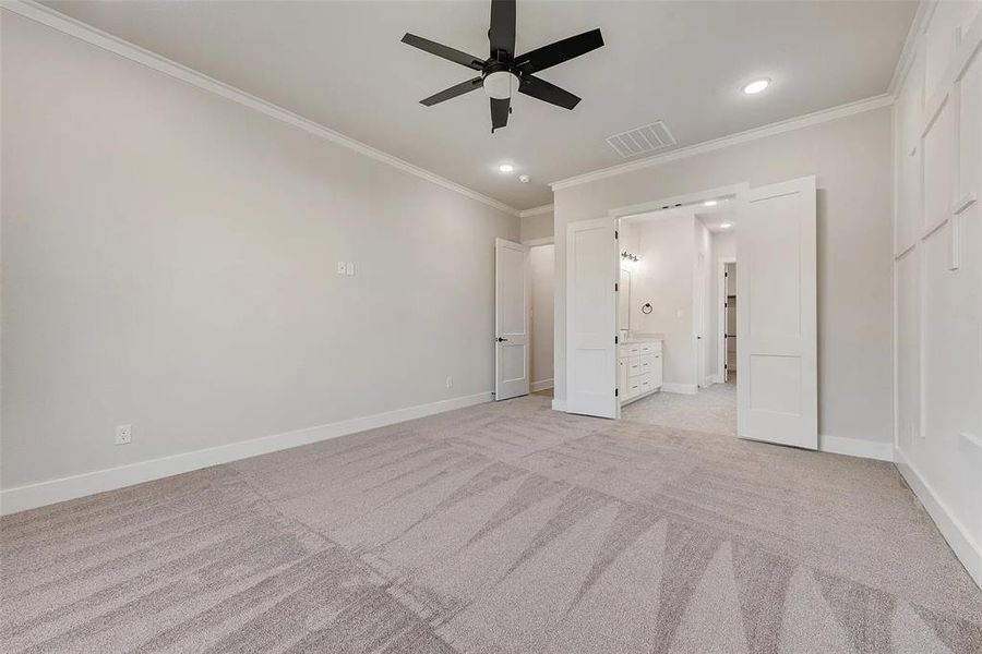 Unfurnished bedroom featuring crown molding, light colored carpet, recessed lighting, ceiling fan, and connected bathroom
