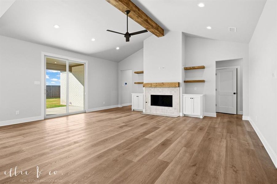 Unfurnished living room featuring a tiled fireplace, ceiling fan, light wood-style floors, and recessed lighting
