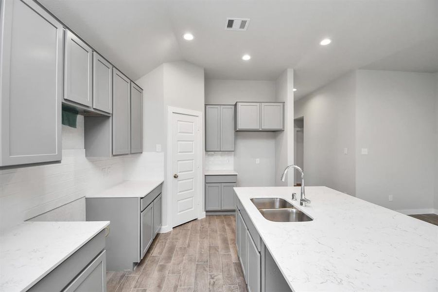 Another view of the kitchen, extended counter space, and massive island. Secondary bedroom. Sample photo of completed plan. As built color and selections may vary.