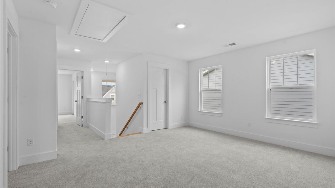 Vibrant carpeted loft offering flexibility as a study nook, game room, or second family space in Moore, SC