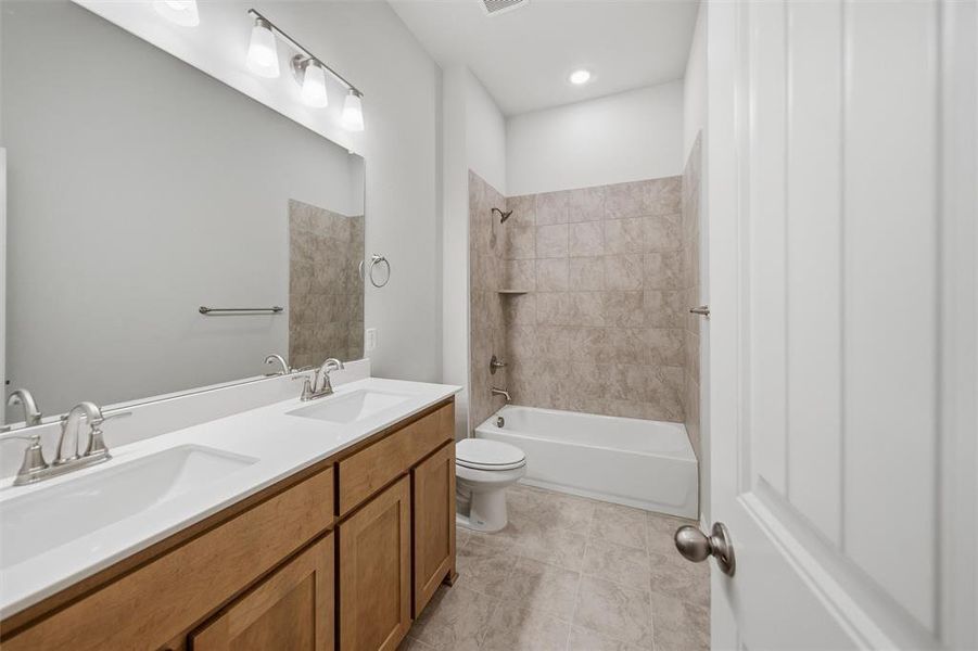 Full bathroom with double vanity, shower / bathtub combination, light tile patterned flooring, and recessed lighting Full bathroom with double vanity, shower / bathtub combination, light tile patterned flooring, and recessed lighting