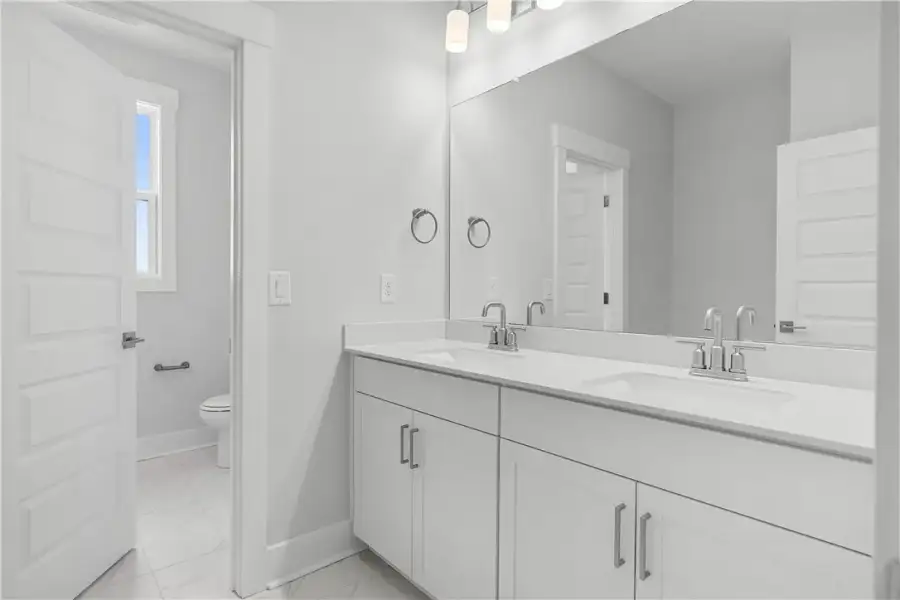 Modern double vanity with white cabinetry and slee Modern double vanity with white cabinetry and slee