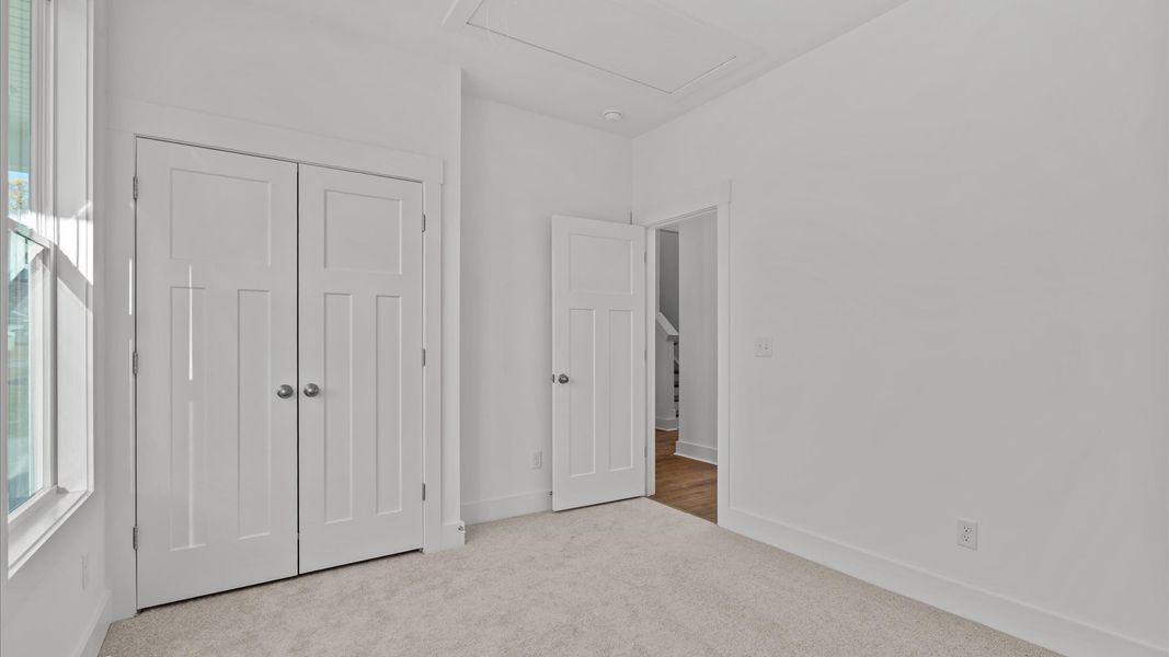 First-class secondary bedroom with comfortable carpeted flooring and generous closet space