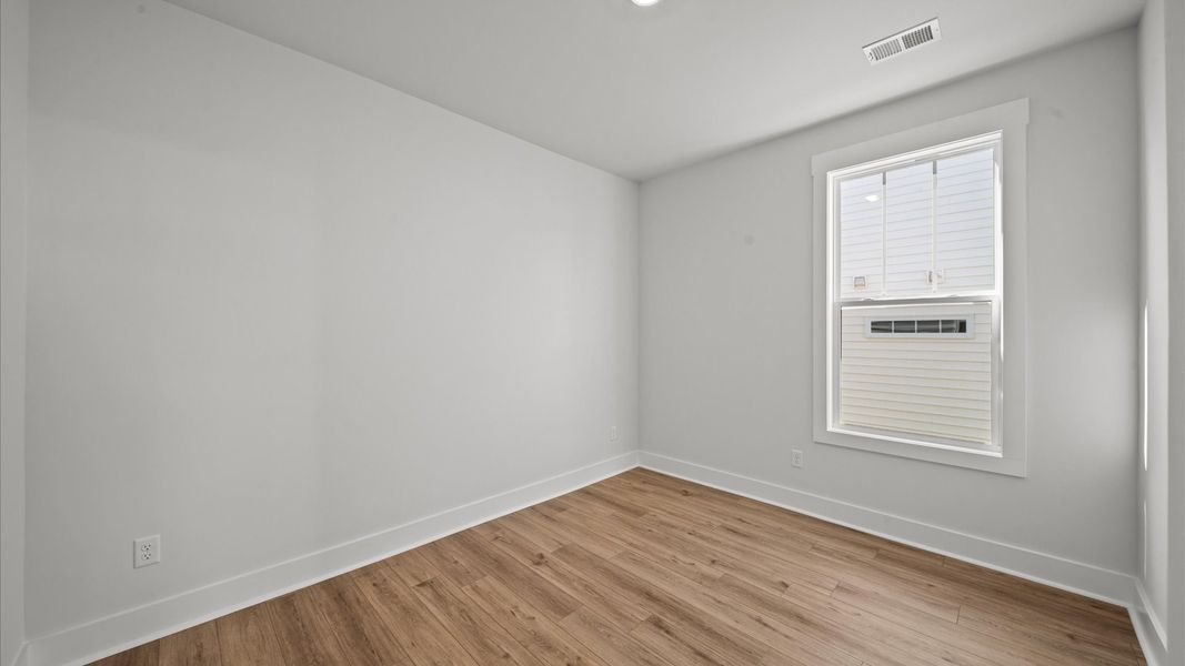 Functional secondary bedrooms with hardwood flooring and modern touches in an exceptional layout