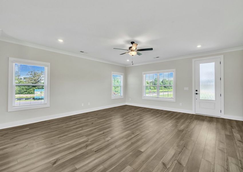The living room has lots of windows and space, perfect for hosting.