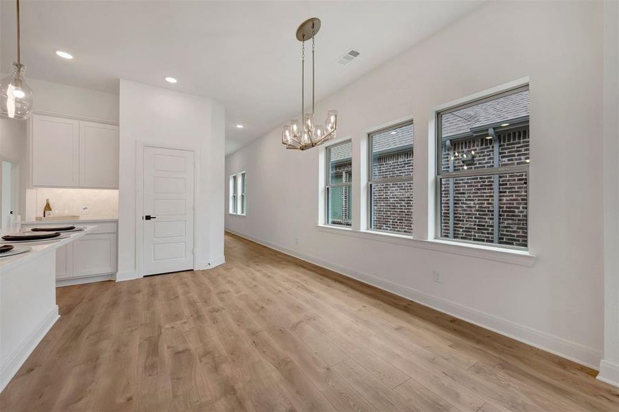 Open-concept living area with wood-finish flooring, white walls, and recessed lighting