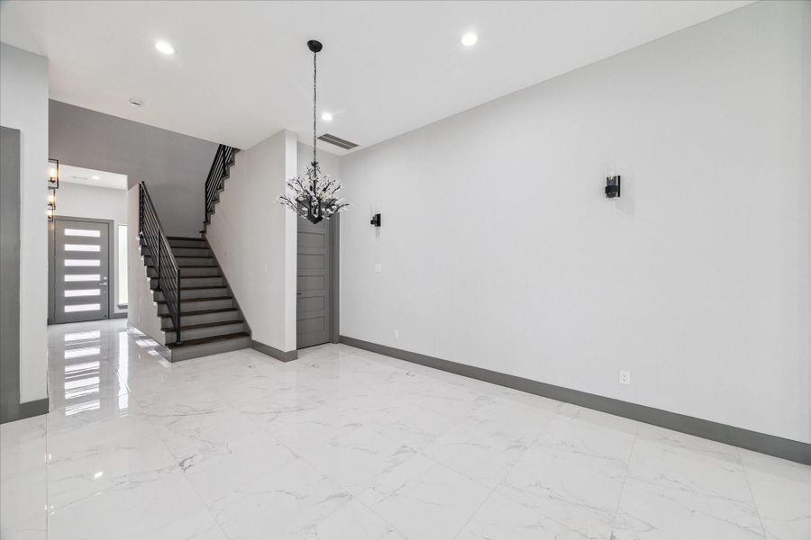 Sleek tile flooring, clean lines, and contemporary lighting create a welcoming space that connects the front entry to the heart of the home. Sleek tile flooring, clean lines, and contemporary lighting create a welcoming space that connects the front entry to the heart of the home.