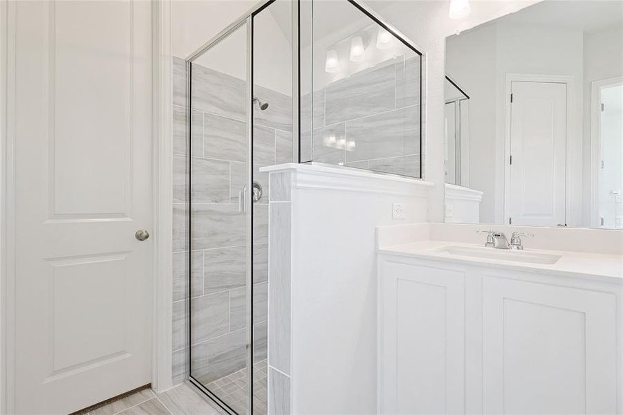 Bathroom featuring vanity and a shower with shower door