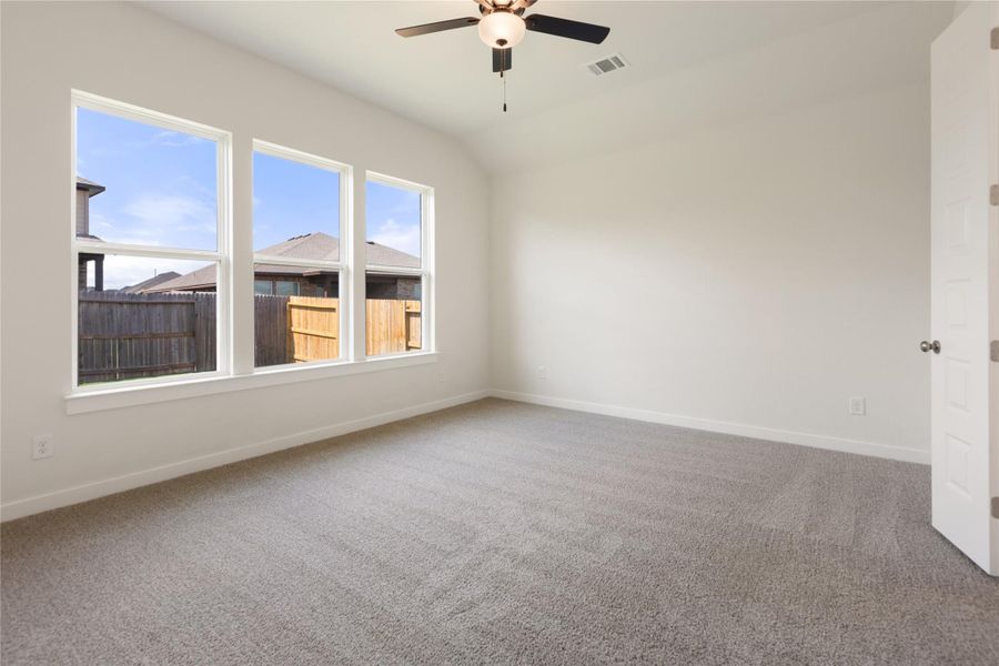 Unfurnished room featuring light colored carpet, lofted ceiling, and ceiling fan