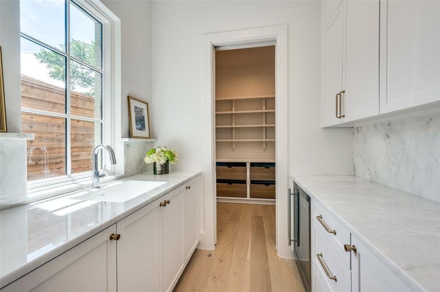 Butler's Pantry featuring secondary sink and custom cabinetry for additional food prep space and storage