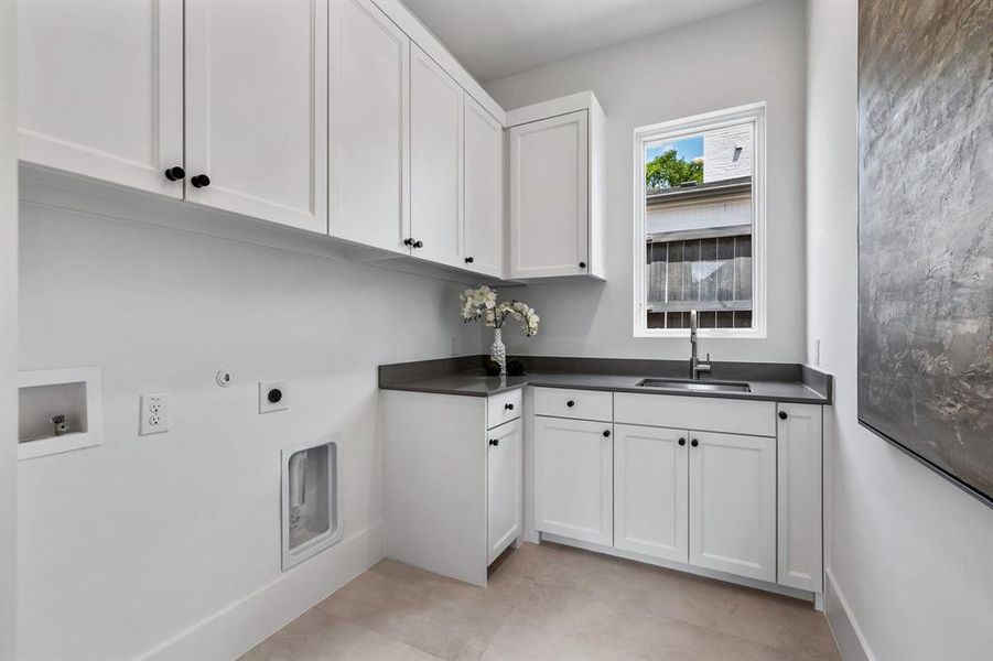 Laundry area with sink, hookup for a gas dryer, cabinets, electric dryer hookup, and light tile patterned flooring