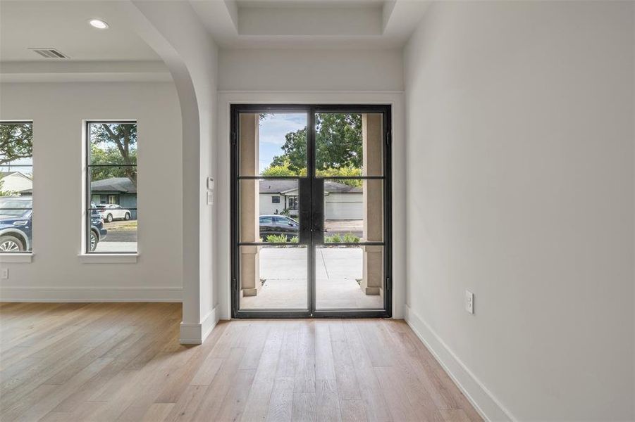 Entryway featuring arched walkways, wood finished floors, plenty of natural light, and recessed lighting Entryway featuring arched walkways, wood finished floors, plenty of natural light, and recessed lighting