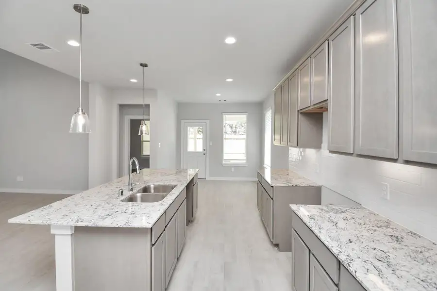 This kitchen is by far any chef’s dream! This spacious kitchen features high ceilings, light stained wood cabinets, granite countertop, SS appliances, modern tile backsplash, recessed lighting, extended counter space, granite kitchen island with double sink, and space for breakfast bar, and a walk-in pantry all overlooking your huge family room. Sample photo of completed home with similar floor plan. Actual colors and selections may vary. This kitchen is by far any chef’s dream! This spacious kitchen features high ceilings, light stained wood cabinets, granite countertop, SS appliances, modern tile backsplash, recessed lighting, extended counter space, granite kitchen island with double sink, and space for breakfast bar, and a walk-in pantry all overlooking your huge family room. Sample photo of completed home with similar floor plan. Actual colors and selections may vary.