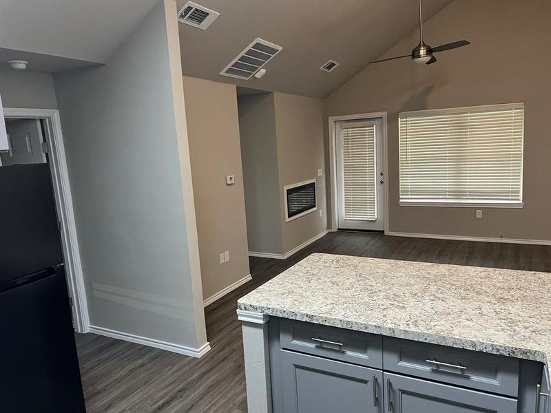 Kitchen with gray cabinets, ceiling fan, dark hardwood / wood-style floors, lofted ceiling, and refrigerator