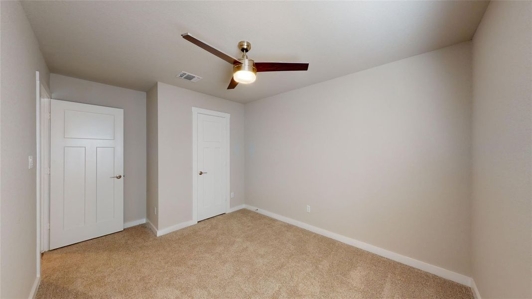 A comfortable bedroom with plush carpet and a stylish ceiling fan provides a serene personal retreat. A comfortable bedroom with plush carpet and a stylish ceiling fan provides a serene personal retreat.