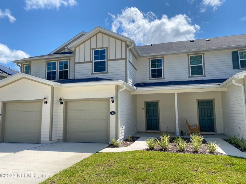 Front exterior of a new home in Orchard Park Townhomes, St. Augustine, FL, highlighting curb appeal (Image 1).