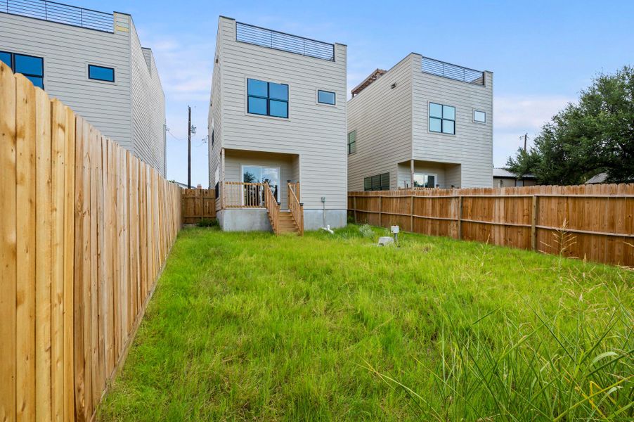 Back of house with a fenced backyard