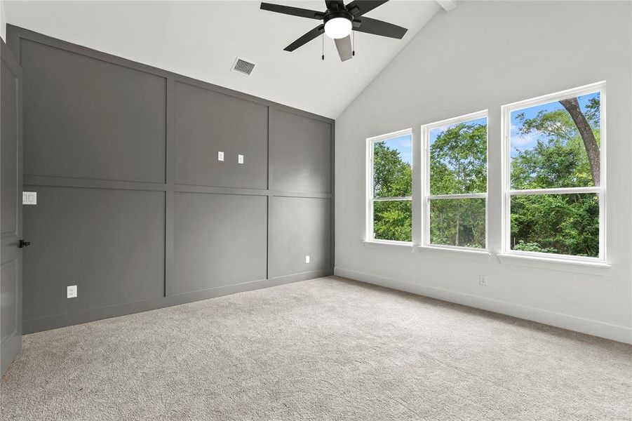 Unfurnished bedroom featuring carpet flooring, high vaulted ceiling, a ceiling fan, and beam ceiling