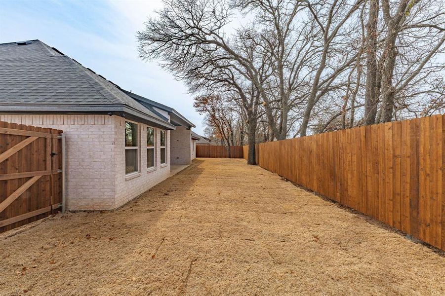 Fenced backyard featuring a gate