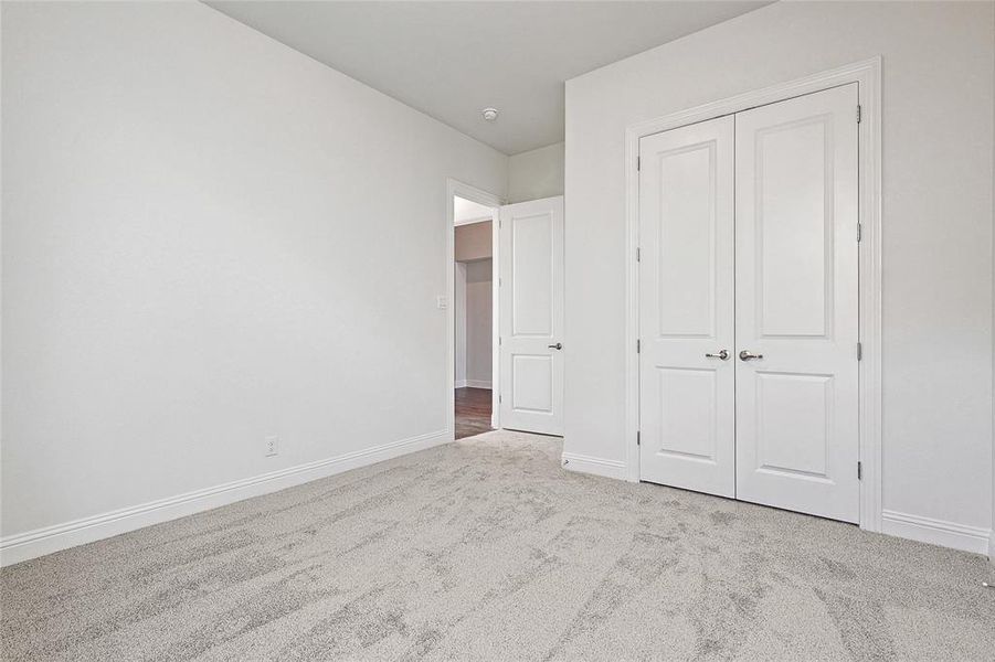 Unfurnished bedroom with a closet and light colored carpet