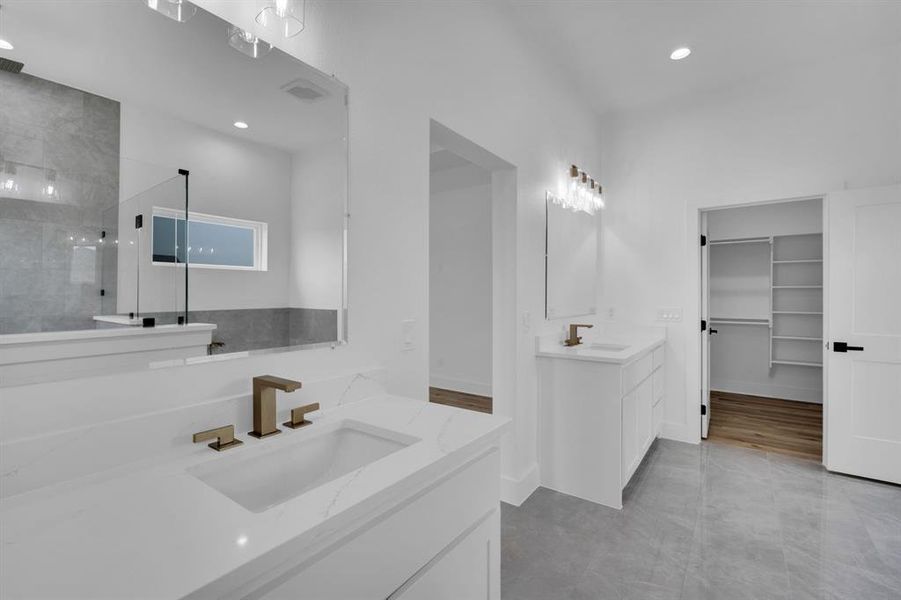 Bathroom featuring double vanity, walk in shower, and hardwood / wood-style floors